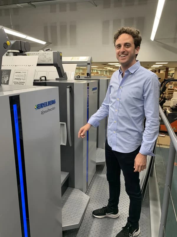 Thomas Group Printing team member by the press