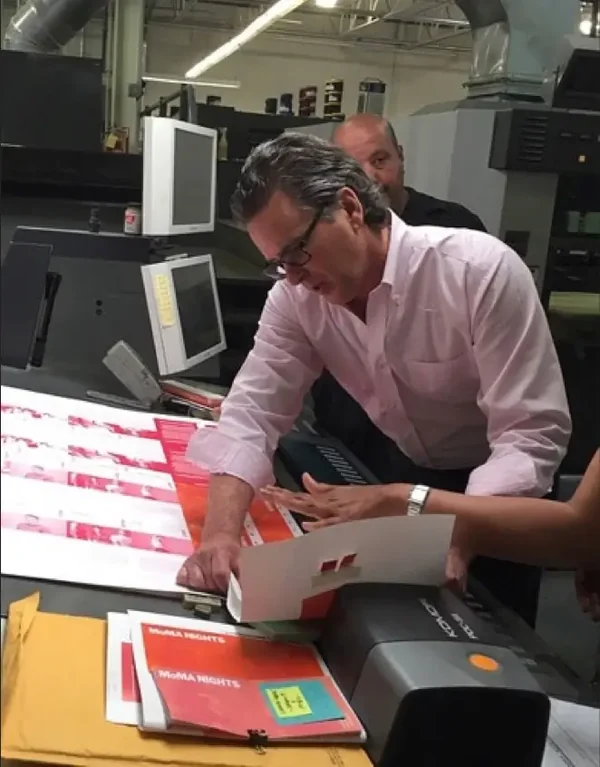 Thomas Group Printing team member inspecting prints at the press