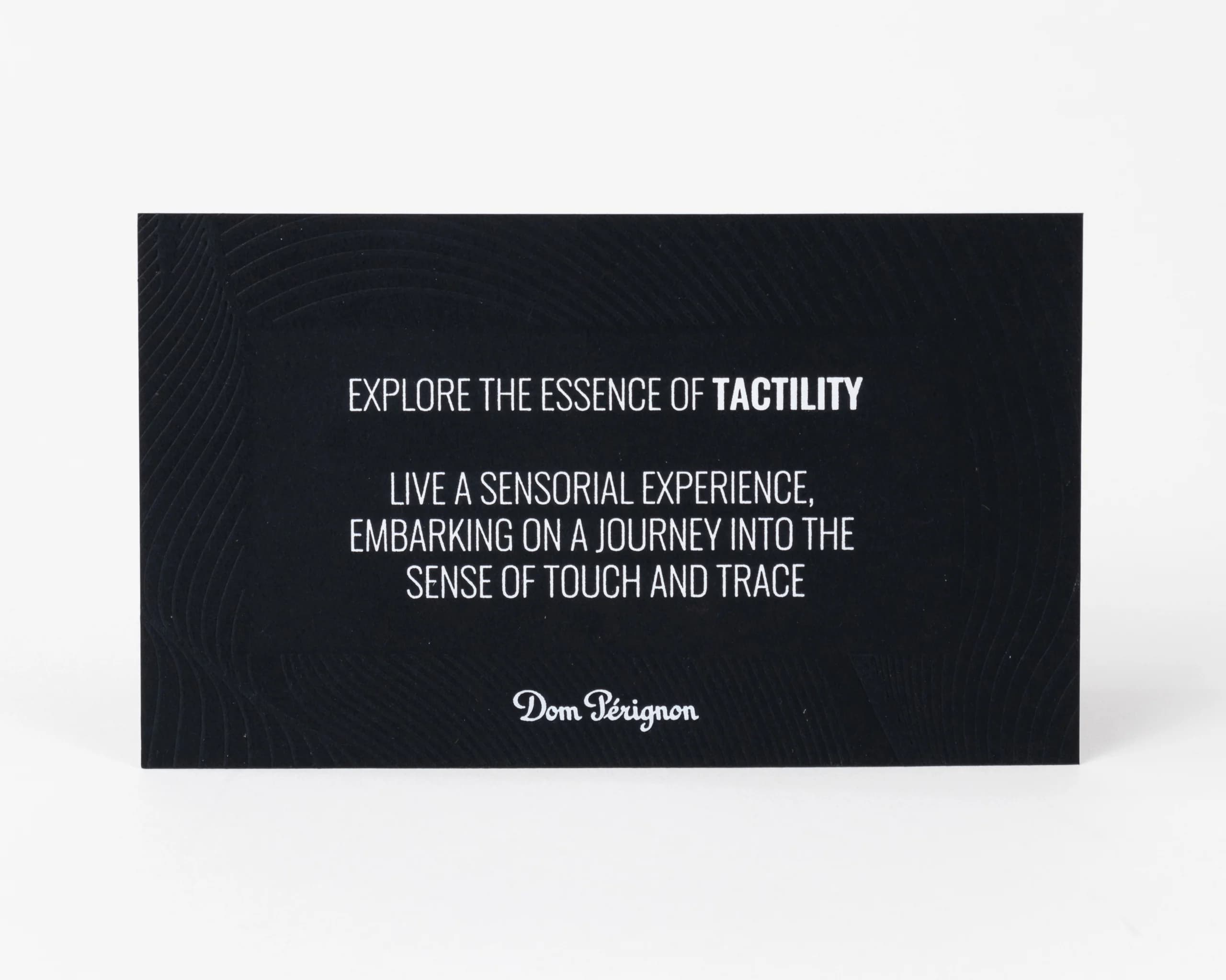 Luxury black Dom Pérignon tactile card with embossed pattern and white typography