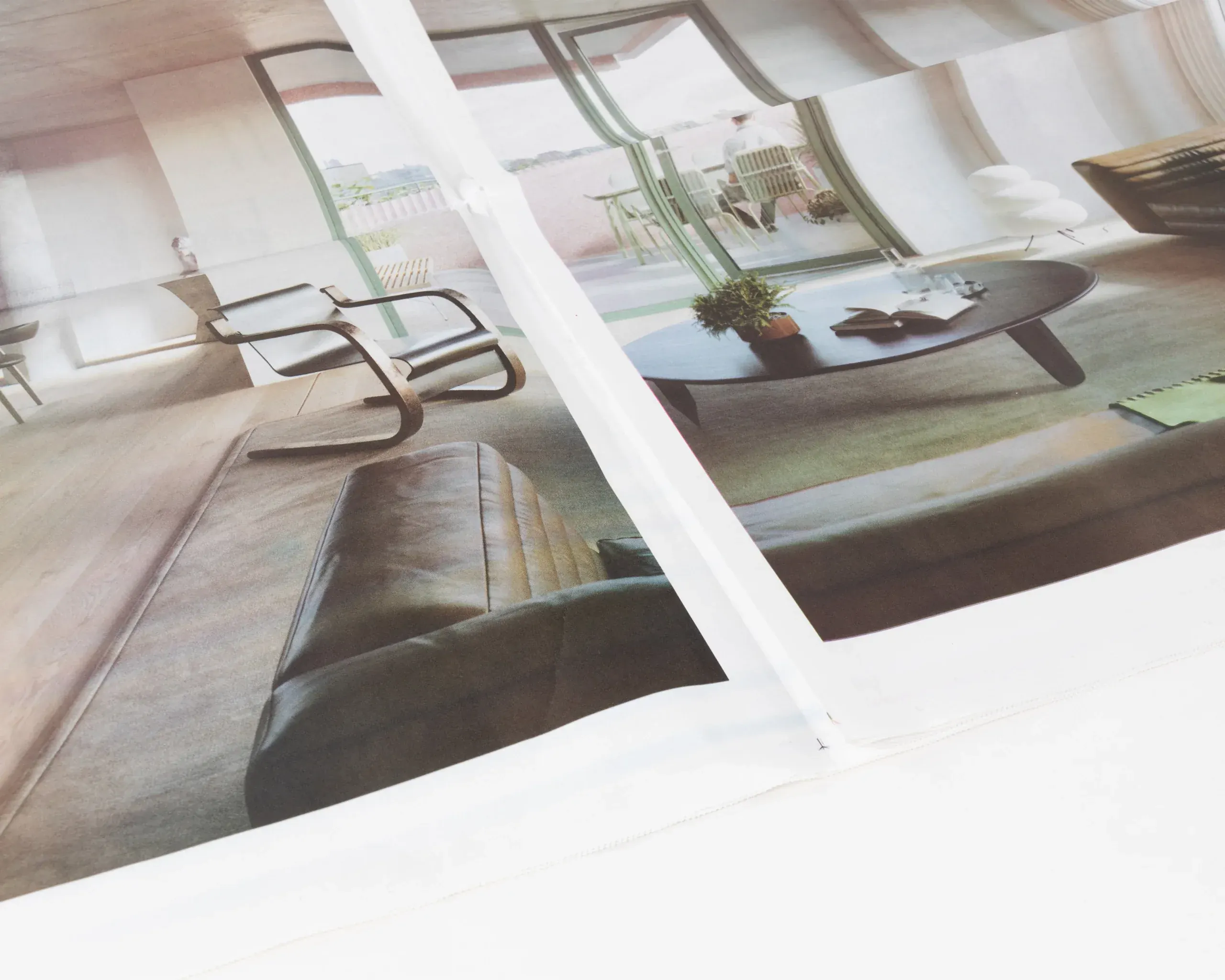 Close-up of real estate newsprint showing outdoor terrace and seating area printed on uncoated stock