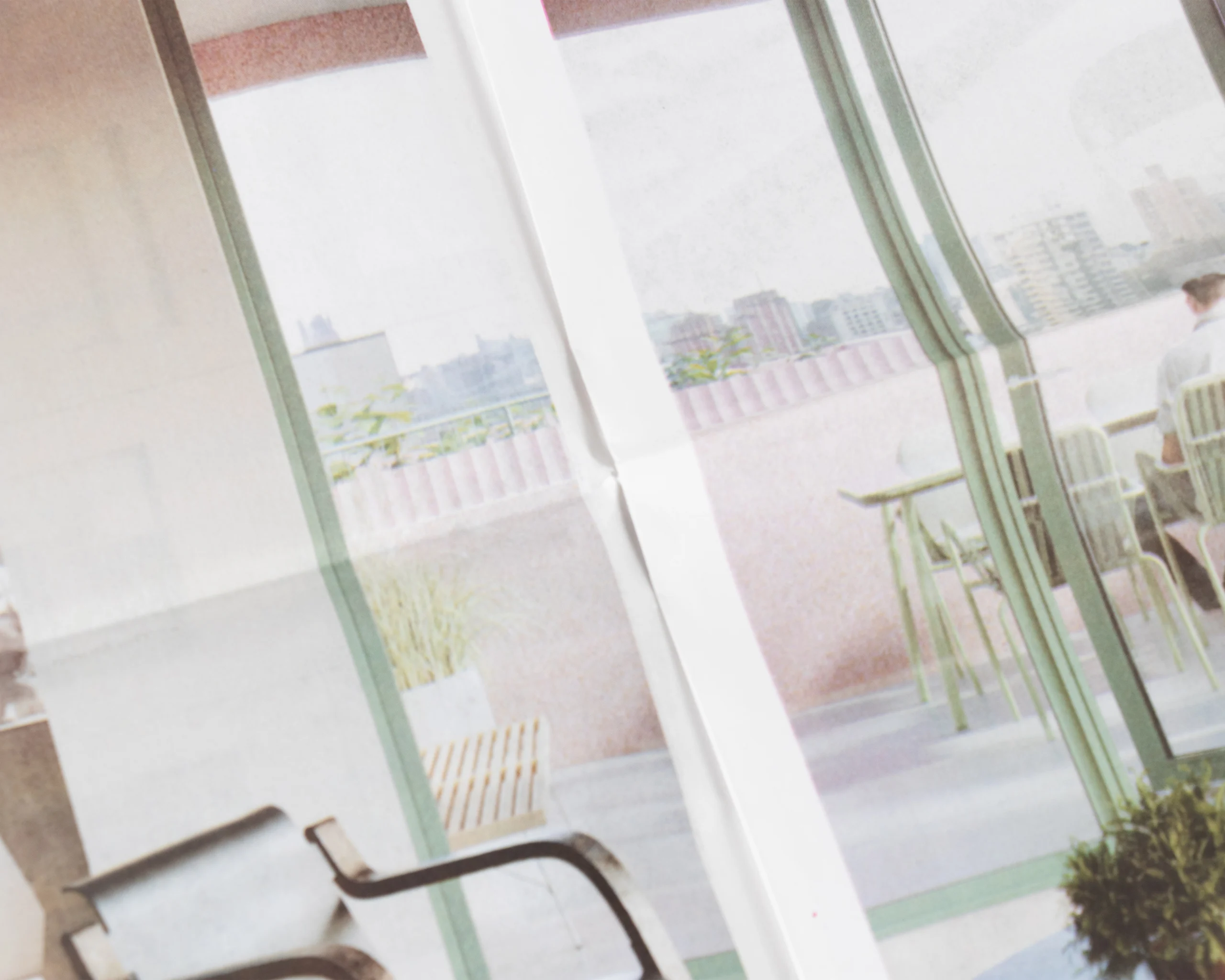 Close-up of real estate newsprint showing outdoor terrace and seating area printed on uncoated stock
