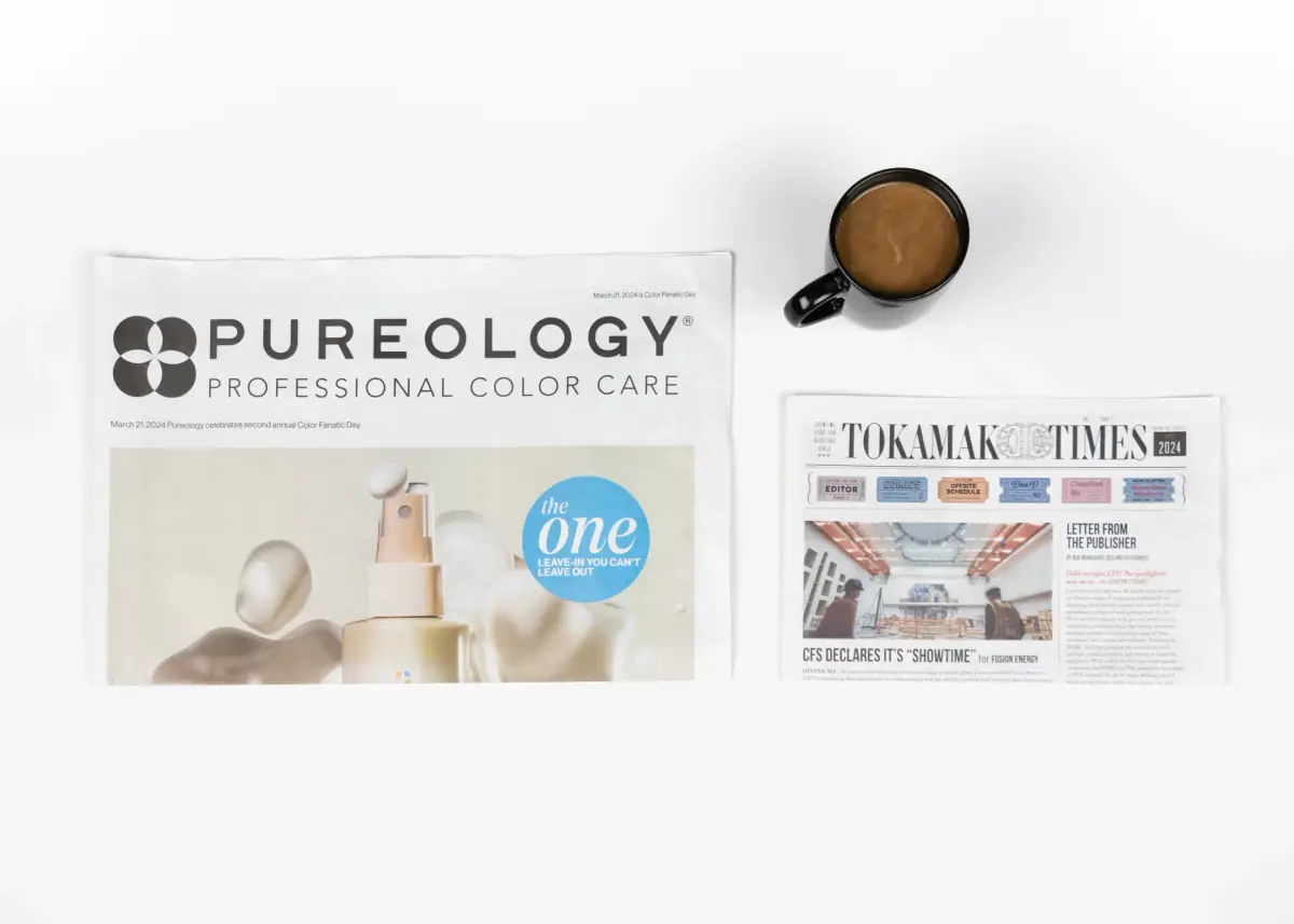 A folded broadsheet newspaper laying next to a folded tabloid newspaper showing their size differences.