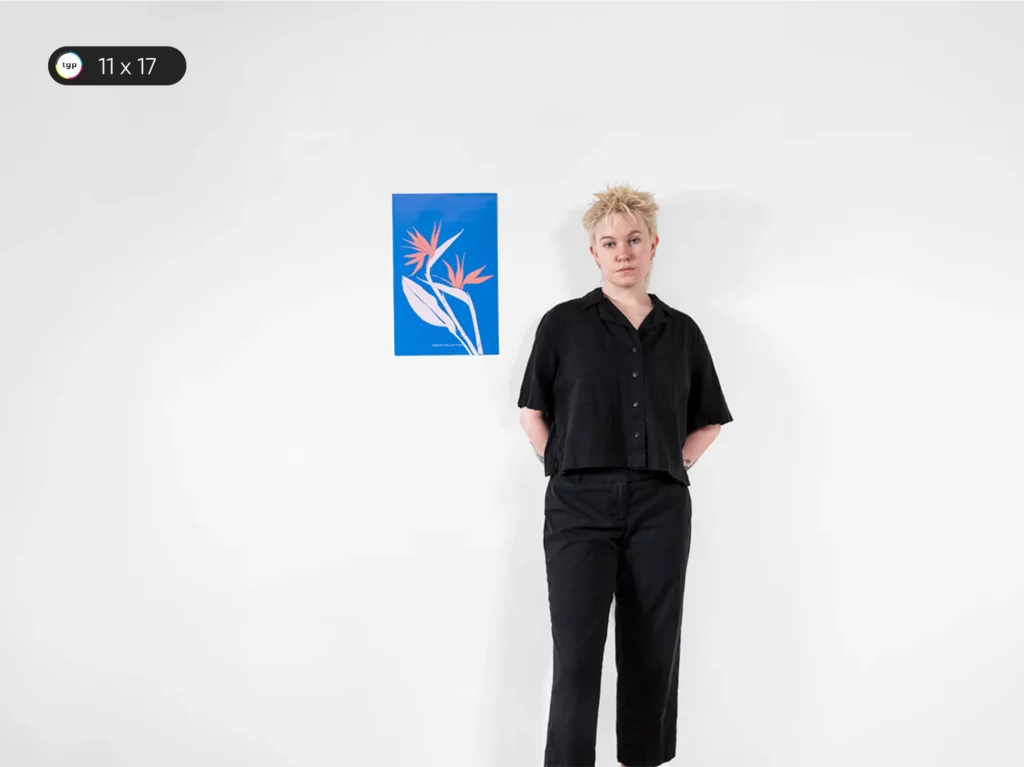 Image shows a model standing by an 11 x 17 inches or A3 size poster, also referred to as Bulletin Poster. The poster's size is comparable to a large drawing pad.