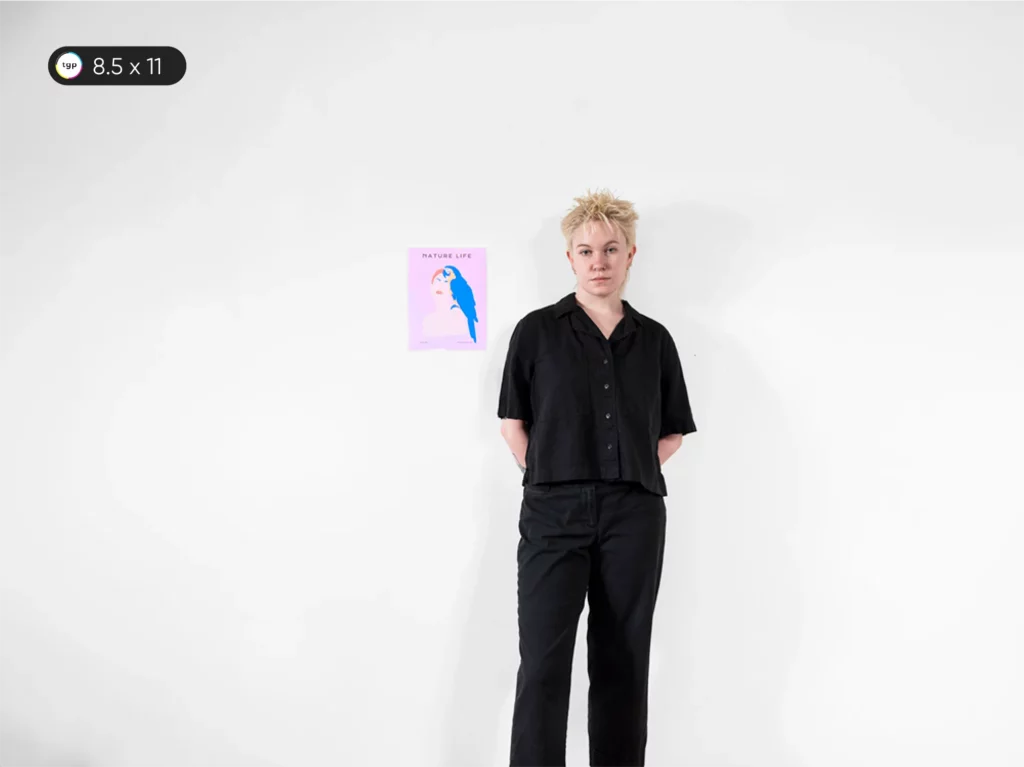 Model standing next to an 8.5 x 11 inches or A4 size poster, also known as Letter Size Poster, for scale. The poster is approximately the size of a standard piece of printer paper.