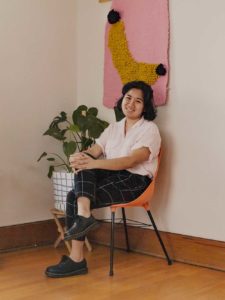 Anh Tran sitting in chair by house plant