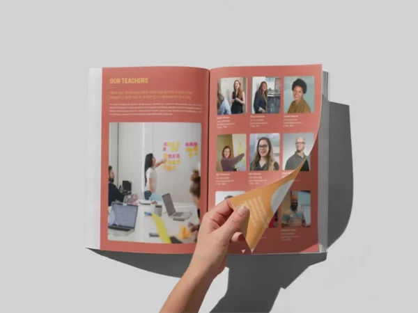 a person leafs through a yearbook printing project produced by Thomas Group Printing.